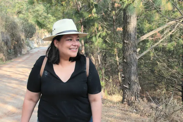 40 yaşındaki Latin bir kadın, doğa ve güneş ışığının tadını çıkarmak için dağlarda yürüyüş yapıyor, refah ve güç kazanıyor.