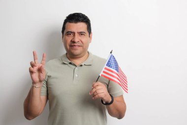 40 yaşındaki esmer tenli Latin bir adam Amerikan bayrağını gösteriyor ve vatandaşlık almak için çalışıyor.