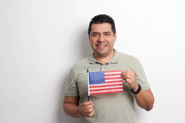 40 yaşındaki esmer tenli Latin bir adam Amerikan bayrağını gösteriyor ve vatandaşlık almak için çalışıyor.