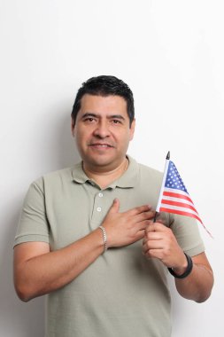 40 yaşındaki esmer tenli Latin bir adam Amerikan bayrağını gösteriyor ve vatandaşlık almak için çalışıyor.