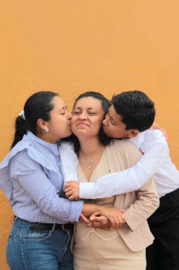 Esmer tenli Latin anne, kız ve oğul sevgilerini sarıl ve anneler gününü aileleriyle kutla.