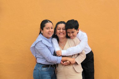 Esmer tenli Latin anne, kız ve oğul sevgilerini sarıl ve anneler gününü aileleriyle kutla.