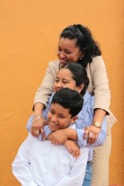 Esmer tenli Latin anne, kız ve oğul sevgilerini sarıl ve anneler gününü aileleriyle kutla.