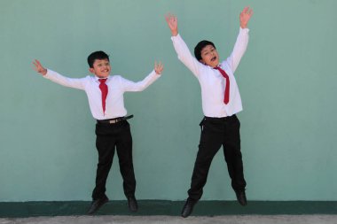 Üniforma giymiş iki koyu tenli Latin erkek sınıf arkadaşı okula döndükleri için heyecanlı ve mutlular.