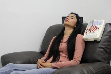 Beyin elektriksel aktivitesini ölçmek ve epilepsi ve uyku bozuklukları gibi beyin sorunlarını teşhis etmek için 20 yaşındaki Latin bir kadına elektroensefalogram.