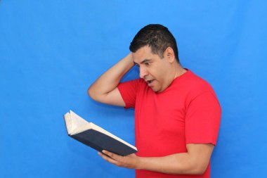 Yetişkin koyu tenli Latin bir adam, bir öğrenci ve öğretmen olarak bilgi edinmek ve öğrenmek için bir kitap okur ve gösterir.