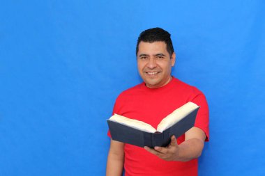 Yetişkin koyu tenli Latin bir adam, bir öğrenci ve öğretmen olarak bilgi edinmek ve öğrenmek için bir kitap okur ve gösterir.