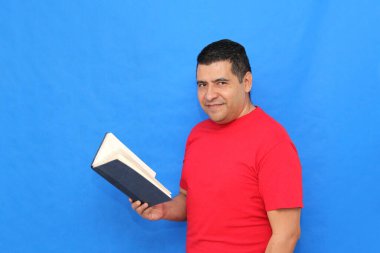 Yetişkin koyu tenli Latin bir adam, bir öğrenci ve öğretmen olarak bilgi edinmek ve öğrenmek için bir kitap okur ve gösterir.