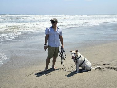 40 yaşındaki bekar Latin erkek, depresyon ve endişe üzerine çalışmak için duygusal destek köpeğiyle plajı seviyor.