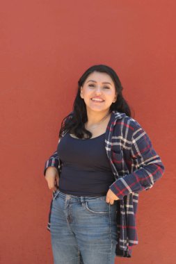 Genç Latin kadın mutlu ve güçlü görünüyor, hayatı dolu dolu ve kişisel ve profesyonel bir başarıyla kutluyor.