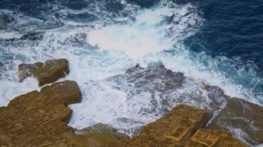 Top view 4k footage of sea blue waves break on rocks. Dunnet Head, Scotland