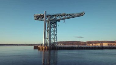 A century-old large crane beside the River Clyde at sunset. Video with the forward camera motion. The Titan Crane, Clydebank, Glasgow, Scotland UK