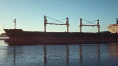 A large cargo ship sailing on a calm river. Bulk Carrier. Logistics and transportation of International, Freight Transportation. River Clyde, Glasgow, United Kingdom