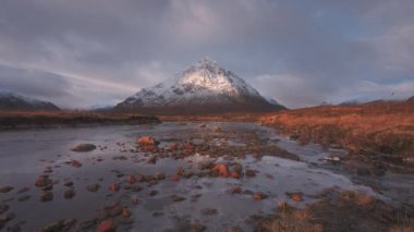 Güneş doğarken Buachaille Etive Mor Dağı ve Coe Nehri 'nin 4K görüntüleri. İskoçya İskoçya, İngiltere. 