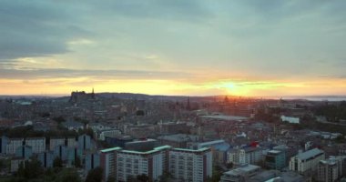 Edinburgh, İngiltere. İskoçya, Edinburgh 'un hava manzarası. Edinburgh şehrinin 4K görüntüsü günbatımı gökyüzünün arka planına karşı. İleri kamera hareketli video. Bulutlu gün batımı gökyüzü