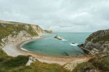 Güney İngiltere 'de Dorset sahilinde kayalık bir kıyı şeridi ve plajla çevrili hilal şeklinde bir deniz koyuna. Durdle Door 'un yanında. Man O War Beach. Yüksek kalite fotoğraf