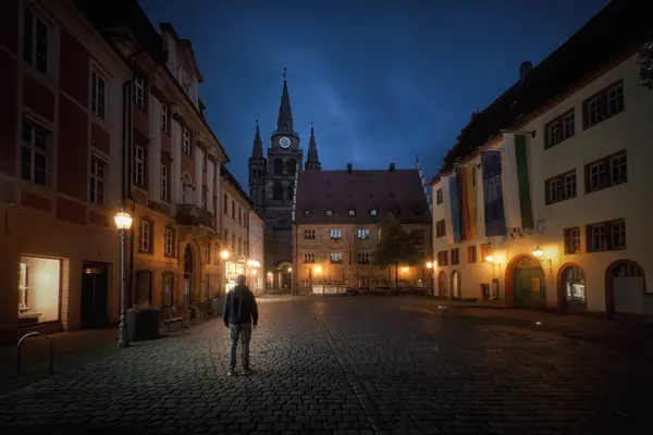 Stock image Square of old German town with street lamps at night a man standing from the back. Ansbach, Bavaria Region Middle Franconia, Germany