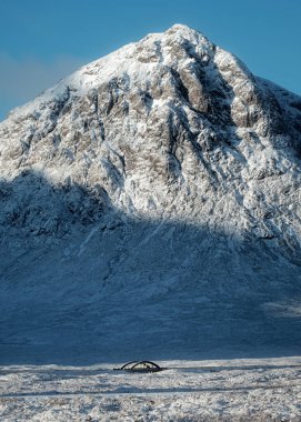 Köprü ve yol, arka planda karlı dağ olan Glen Coe 'nun İskoç Dağları' ndan geçiyor. Buachaille Etive Mor. İskoçya