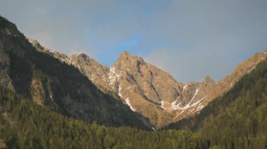 Dağda hareket eden bulutlarla gün batımının hızlanması. Işığı gün ışığından gün batımına ve alacakaranlığa çevirmek. Alp manzarası, Tyrol, Avusturya. Yüksek kalite 4k görüntü