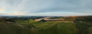 Gün batımında kırsal alanların ve yeşil tepelerin havadan panoramik görüntüsü. Güzel kırsal alan ve doğa arka planı. Beecraigs Country Park, Batı Lothian, İskoçya