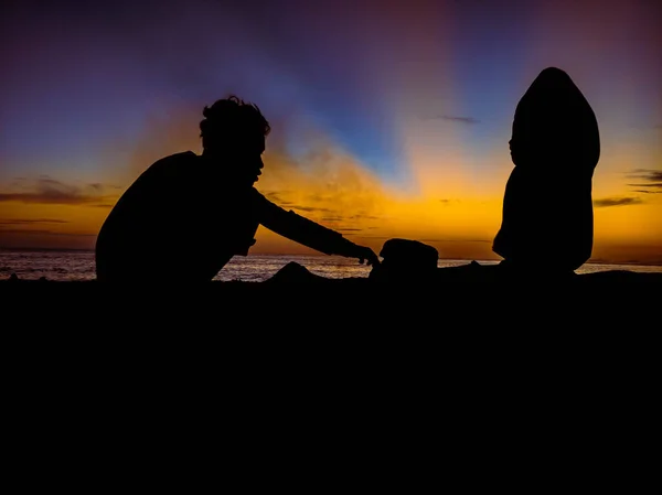 silhouette of people with sunrise on the beach