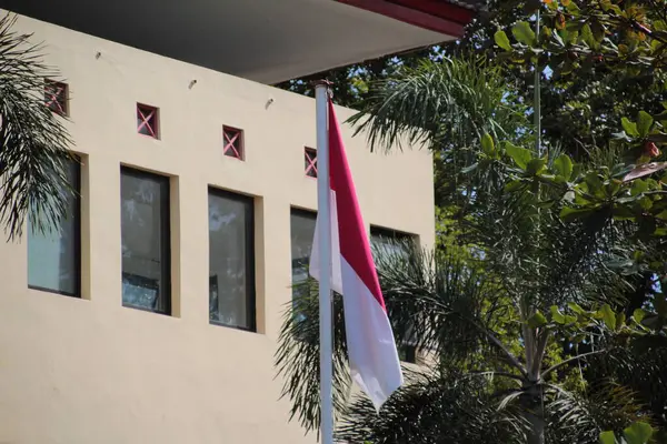 stock image Indonesian flag waving proudly in front of government building