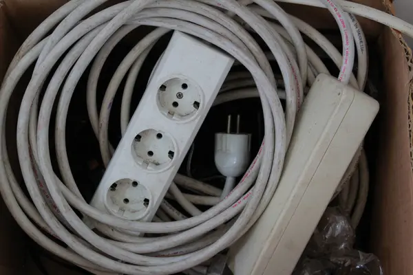 stock image white electrical socket with cable coiled in a cardboard box