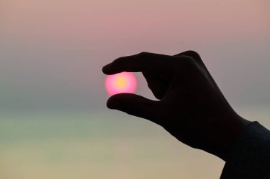 Gün doğumunu tutan parmaklar silueti