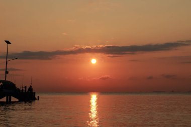 Güneşin doğuşu açık gökyüzü ile sahil iskelesi köprüsünde