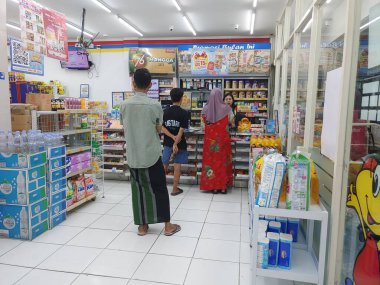 Lombok, Endonezya, 12 Şubat 2024 - Endonezyalı asgari market personeli ödeme sürecini bekliyor