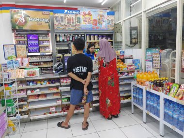Lombok, Endonezya, 12 Şubat 2024 - Endonezyalı asgari market personeli ödeme sürecini bekliyor