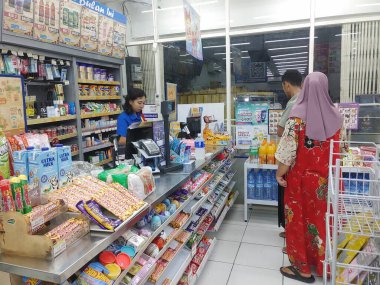 Lombok, Endonezya, 12 Şubat 2024 - Endonezyalı asgari market personeli ödeme sürecini bekliyor