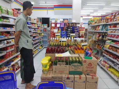 Lombok, Endonezya, 12 Şubat 2024 - Müşteriler Endonezya 'daki bir minimarket mağazasında ürünlere bakıyorlar