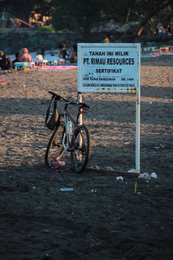 Lombok, 2 Mart 2024, Endonezya - dağ bisikleti Loang Balok plajında demir levhaya yaslanıyor.