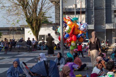 Bir balon satıcısı kalabalığın ortasında satıyor, Bertais Lombok, Endonezya, 23 Haziran 2024