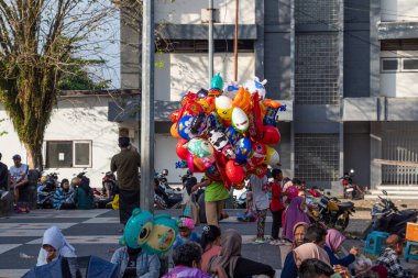 Bir balon satıcısı kalabalığın ortasında satıyor, Bertais Lombok, Endonezya, 23 Haziran 2024