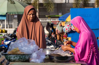 Eski Endonezyalı tüccarlar müşterileri satıp hizmet ediyorlar. Bertais Lombok, Endonezya, 23 Haziran 2024