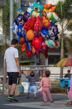 Kalabalığın ortasında balonla küçük bir çocuk, Bertais Lombok, Endonezya, 23 Haziran 2024