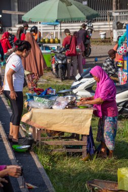 Eski Endonezyalı tüccarlar müşterileri satıp hizmet ediyorlar. Bertais Lombok, Endonezya, 23 Haziran 2024