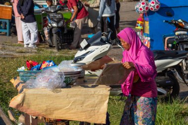 Eski Endonezyalı tüccarlar müşterileri satıp hizmet ediyorlar. Bertais Lombok, Endonezya, 23 Haziran 2024