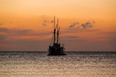 Ufuk çizgisinde gün batımı olan bir gemi gezintisi.