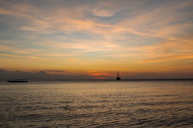 Ufuk çizgisinde gün batımı olan bir gemi gezintisi.