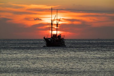 Ufuk çizgisinde gün batımı olan bir gemi gezintisi.