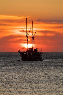 Ufuk çizgisinde gün batımı olan bir gemi gezintisi.