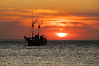 Ufuk çizgisinde gün batımı olan bir gemi gezintisi.