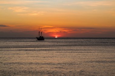 Ufuk çizgisinde gün batımı olan bir gemi gezintisi.