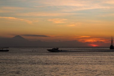 Ufuk çizgisinde gün batımı olan bir gemi gezintisi.
