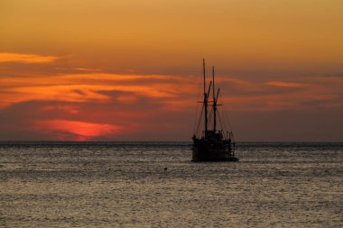 Ufuk çizgisinde gün batımı olan bir gemi gezintisi.