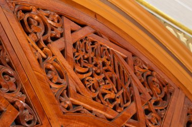 Tahta oymalar, caminin ahşap kapıları üzerine Allah 'ın adının anıldığı Arapça bir yazı.