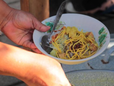 Bir kase soto. Tipik bir Endonezya yemeği. Parçalanmış tavuk ve sebze soslu.